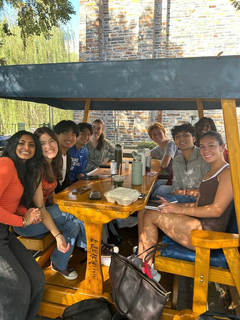 Brothers studying and socializing at an outdoor table on campus